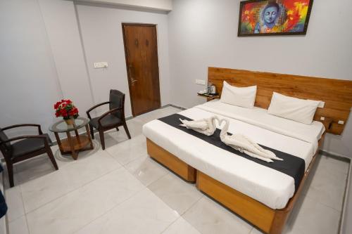 a bedroom with a bed with two towels on it at Hotel Vaishnavi Classic in Secunderabad