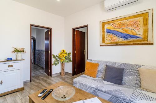 a living room with a couch and a painting on the wall at Casa Sabino in Almádena