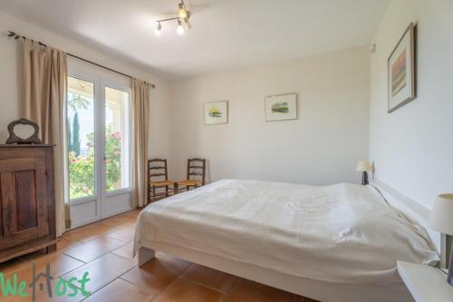 une chambre blanche avec un lit et une fenêtre dans l'établissement Bouenhoure - Famille House Swimming pool in Aix, à Aix-en-Provence