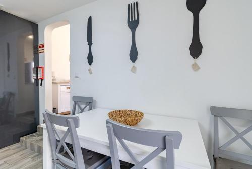 a dining room with a white table and fork hooks at Casa Sabino in Almádena