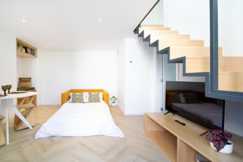 ein Schlafzimmer mit einem Bett und einer Treppe in der Unterkunft T0 do Carril, Aveiro in Aveiro