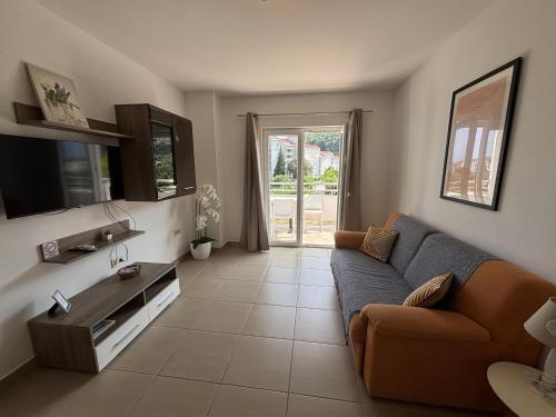 a living room with a couch and a tv at Apartments Villa Katija in Drvenik