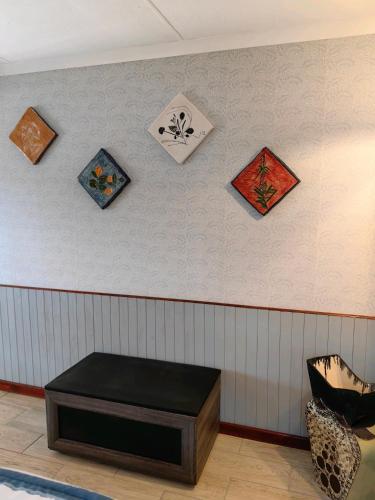 a room with a table on a wall with paintings at House of Art in Haenertsburg