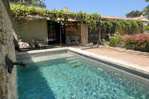 una piscina en un patio con una casa en Gîte tout confort - jardin et piscine chauffée, en Lagnes