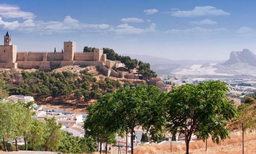 a castle on top of a hill with trees at Casa Mariquilla in Antequera