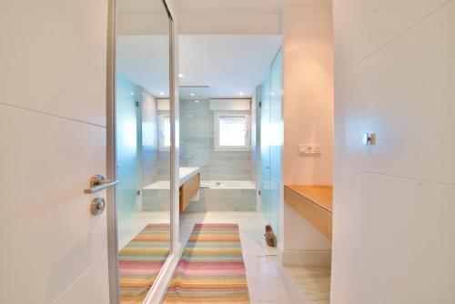 un couloir avec une porte vitrée et un tapis coloré dans l'établissement Casa Amarna, à La Herradura