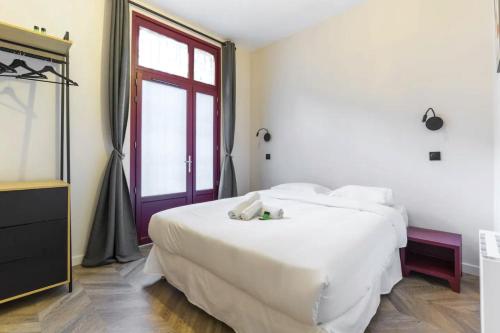 une chambre avec un grand lit blanc et une fenêtre dans l'établissement HSH Saint Lazare-Opéra Calm & Cosy Apartement, à Paris