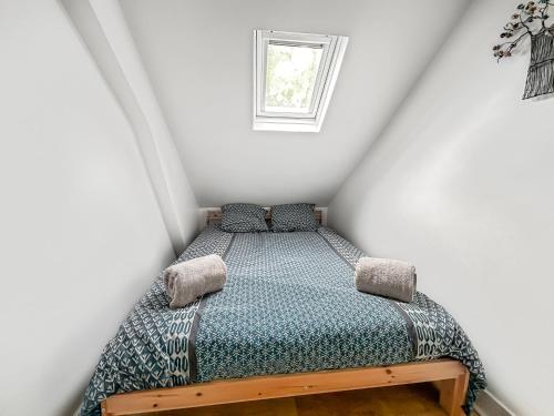 une petite chambre avec un lit dans un grenier dans l'établissement Charmant studio - vue parc- proche transports, à Tours