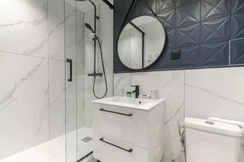 une salle de bain avec une douche, un lavabo et un miroir dans l'établissement HSH Saint Lazare-Opéra Calm & Cosy Apartement, à Paris