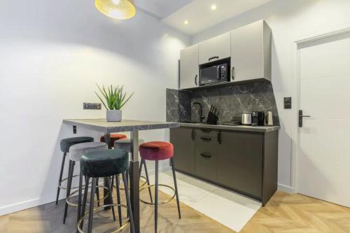 une cuisine avec un comptoir et des tabourets dans une pièce dans l'établissement HSH Saint Lazare-Opéra Calm & Cosy Apartement, à Paris