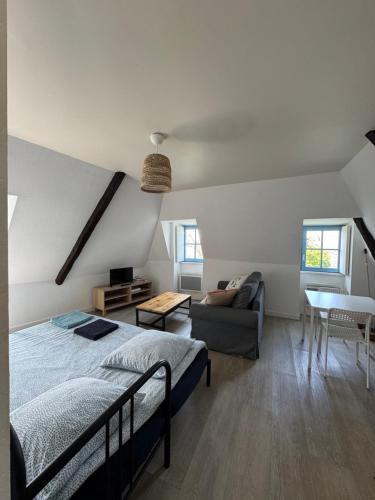 une chambre avec un lit, un canapé et une table dans l'établissement Le CulSalé joli studio au cœur des remparts avec vue imprenable sur les toits, à Guérande
