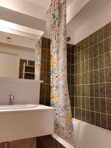 une salle de bain avec un rideau de douche et un lavabo dans l'établissement studio bord de mer avec parking, à Sète