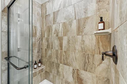 a bathroom with a shower with a glass door at Spacious Country Farmhouse Retreat, Sleeps 16, Pool, Movie Room in Papillion