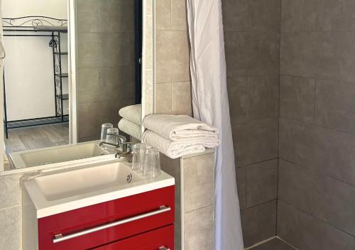 a bathroom with a red sink and a shower at Hôtel Le Carnon in Carnon-Plage