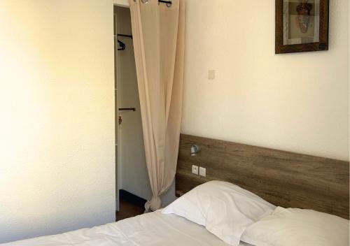 a bedroom with a bed with a wooden head board at Hôtel Le Carnon in Carnon-Plage