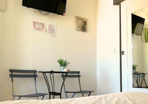 a table and two chairs in a room at Hôtel Le Carnon in Carnon-Plage