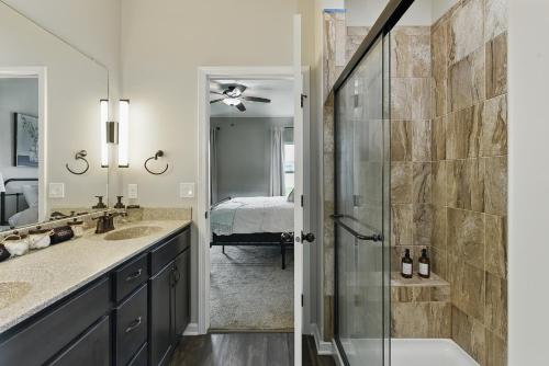 a bathroom with a walk in shower next to a sink at Spacious Country Farmhouse Retreat, Sleeps 16, Pool, Movie Room in Papillion