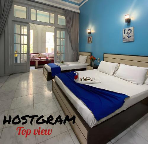 two beds in a room with blue walls at Hostgram Top View in Cairo