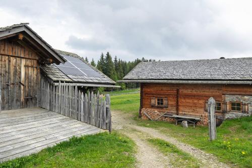 a wooden building with a wooden ramp next to a building at Almhütte Laffaa in Rodengo