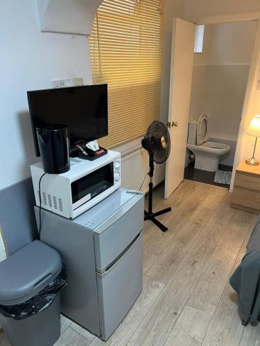 a room with a microwave and a television on a table at Economic room Sheperds Bush - hotel-like room in London