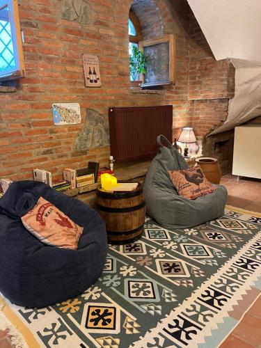 Una sala de estar con dos sillones puf sobre una alfombra. en Wine Cellar Hostel, en Tiflis