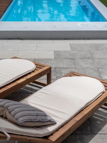 two beds on a patio next to a swimming pool at Tapada do Sobral in Vilar de Ferreiros