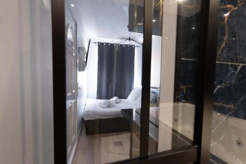 a reflection of a bedroom with a bed in a mirror at Le Passion Room - Love Room - Jacuzzi in Beauvais