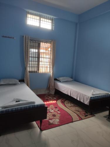 a blue room with two beds and a window at Retro Lodge in Nāzirā
