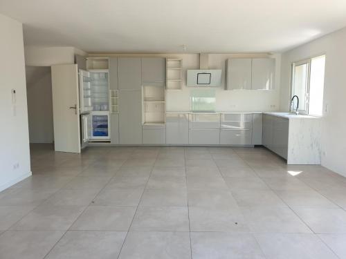 Il comprend une grande cuisine avec des placards blancs et du carrelage. dans l'établissement Maison HYERES La Bayorre, à Hyères