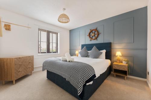 a bedroom with a bed and a clock on the wall at Drift & Dune in Poole