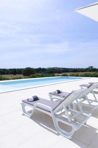 a pair of lounge chairs on a patio next to a swimming pool at Monte de São Francisco Country House in Vale de Maceira