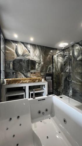 La salle de bains est pourvue d'une baignoire blanche. dans l'établissement Gite ARBOR VITAE, à La Crau