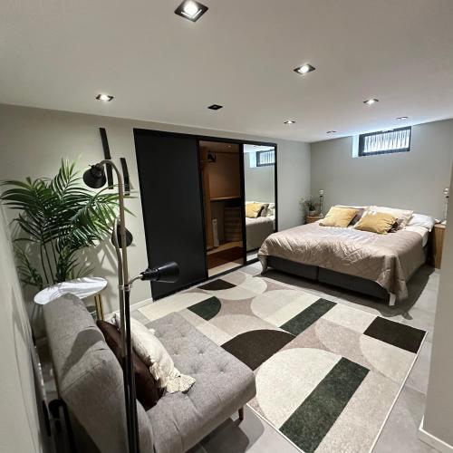 a bedroom with a bed and a couch at Ground floor apartment near the sea, golf, lake, and forest in Hovås