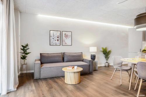 una sala de estar con un sofá y una mesa en Midtown Nest, en Aarhus