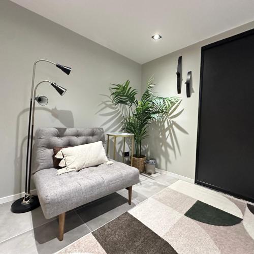 a living room with a chair and a lamp at Ground floor apartment near the sea, golf, lake, and forest in Hovås