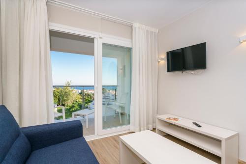 a living room with a blue couch and a tv at Minura Sur Menorca in Punta Prima