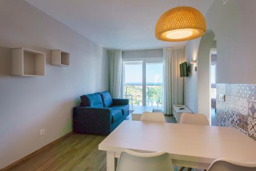 a living room with a table and a blue chair at Minura Sur Menorca in Punta Prima