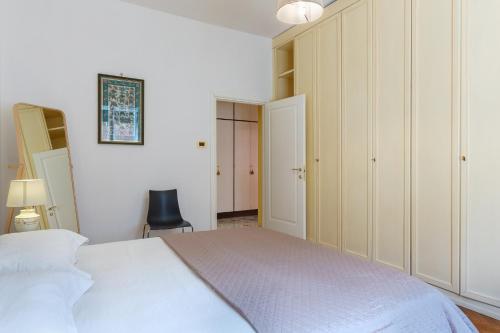 a bedroom with a white bed and a black chair at Mercato delle Erbe Big Apartment in Bologna