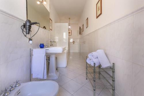a white bathroom with a sink and a toilet at Mercato delle Erbe Big Apartment in Bologna