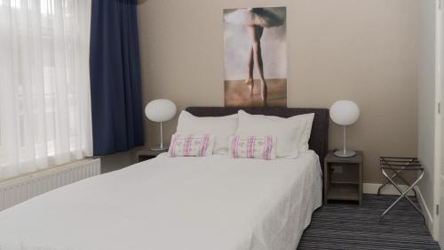 1 dormitorio con 1 cama con sábanas y almohadas blancas en B&B House No 7, en Ámsterdam
