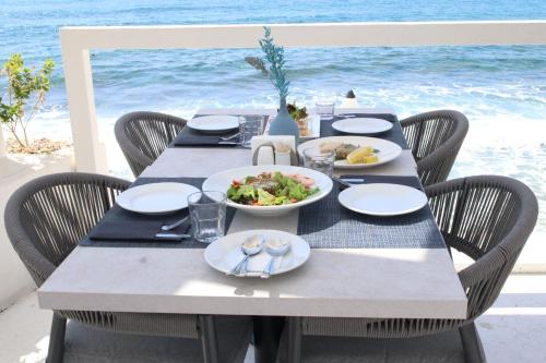 a table with plates of food on the beach at Escape by Orchid in Batroûn