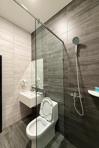 a bathroom with a shower and a toilet and a sink at LeLian Hotel SIBUJAYA in Sibu