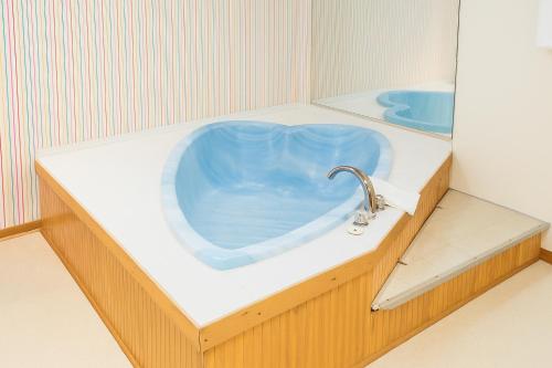 a bathroom with a blue tub with a faucet at Ventura Motel in Ludington