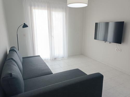 a living room with a couch and a flat screen tv at Holiday home with view in Pefkohori