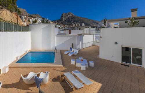 a house with a swimming pool and lounge chairs at Altea Beach Villas in Altea