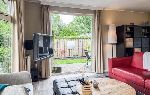 a living room with a red couch and a tv at 2 Bedroom Nice Home In Ochten in Ochten