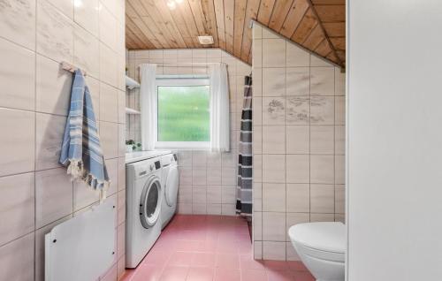 a bathroom with a washing machine and a toilet at 4 Bedroom Pet Friendly Home In Blåvand in Ho