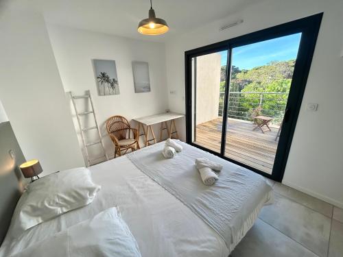 une chambre avec un grand lit blanc et un balcon dans l'établissement Appartement luxe Le Levant, à Hyères