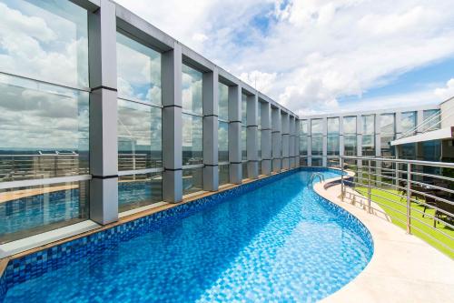 ein Balkon mit einem Swimmingpool auf einem Gebäude in der Unterkunft Fusion Hotel em Brasília 15451 in Brasilia