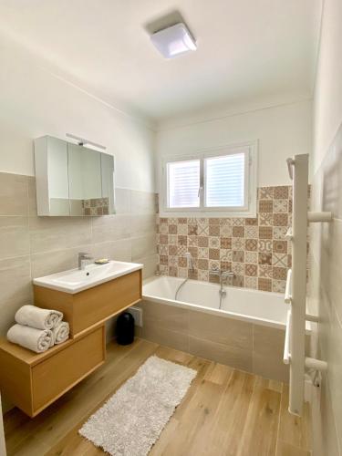 une salle de bain blanche avec une baignoire et un lavabo dans l'établissement Appartement dans Villa à Antibes avec Vue Mer, à Antibes